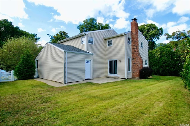 rear view of property featuring a lawn and a patio