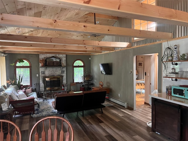 living room featuring hardwood / wood-style flooring, a healthy amount of sunlight, a fireplace, and a baseboard heating unit