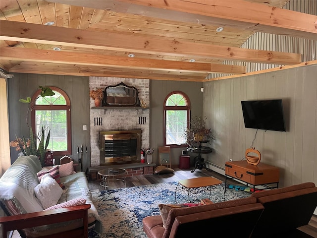 living room featuring a fireplace, hardwood / wood-style floors, a baseboard radiator, and a wealth of natural light