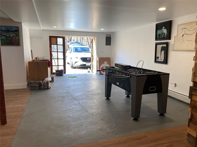 playroom featuring baseboard heating and concrete floors