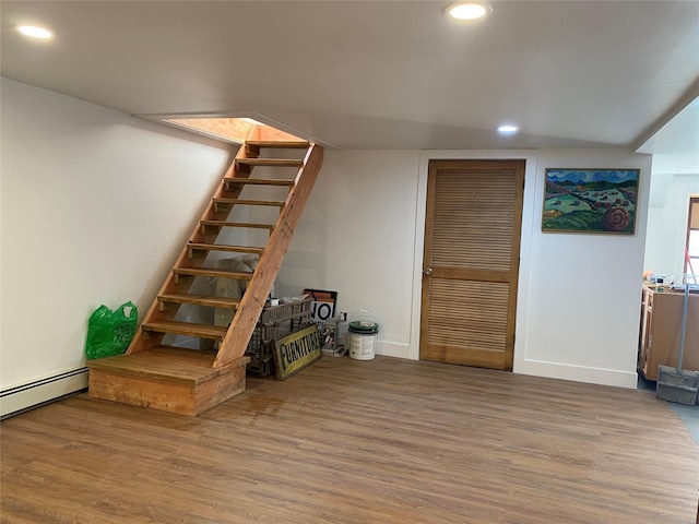 basement featuring wood-type flooring and baseboard heating