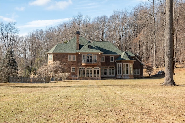 back of property featuring a lawn and french doors