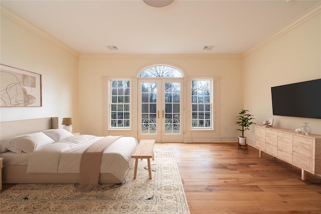 bedroom with crown molding, french doors, and light wood-type flooring