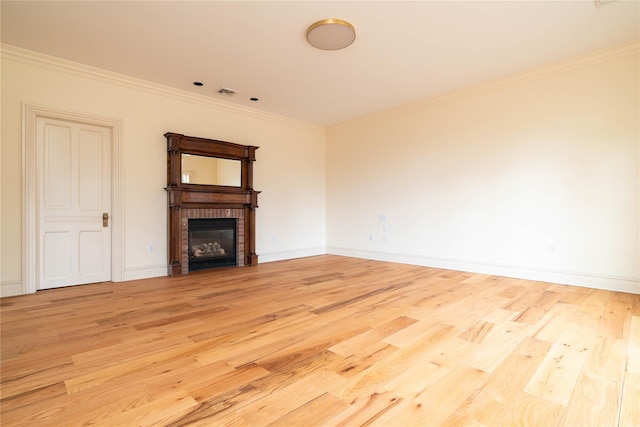 unfurnished living room with light hardwood / wood-style floors, a brick fireplace, and crown molding