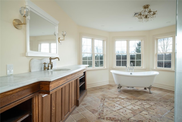 bathroom with a bathtub, vanity, and a chandelier