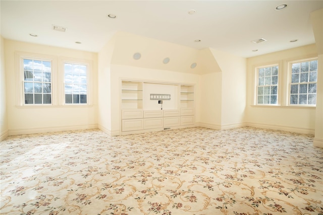 unfurnished living room with built in shelves and a healthy amount of sunlight