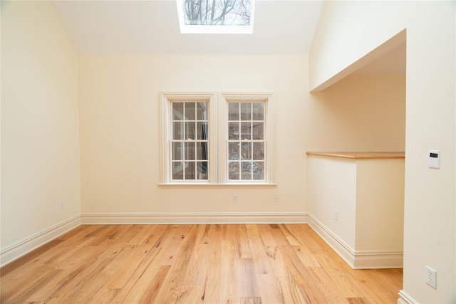 empty room featuring light hardwood / wood-style floors and a skylight