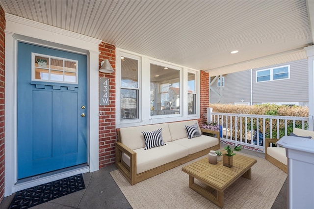 view of exterior entry featuring covered porch and outdoor lounge area