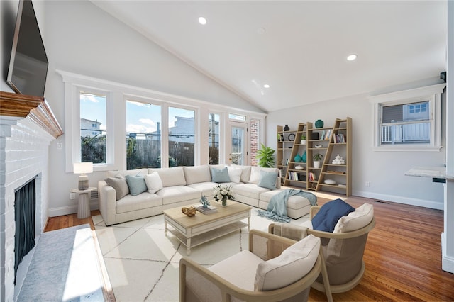 living room with high vaulted ceiling, light wood-type flooring, and a brick fireplace