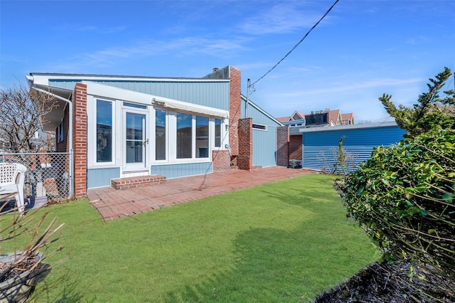 back of house with a lawn and a patio