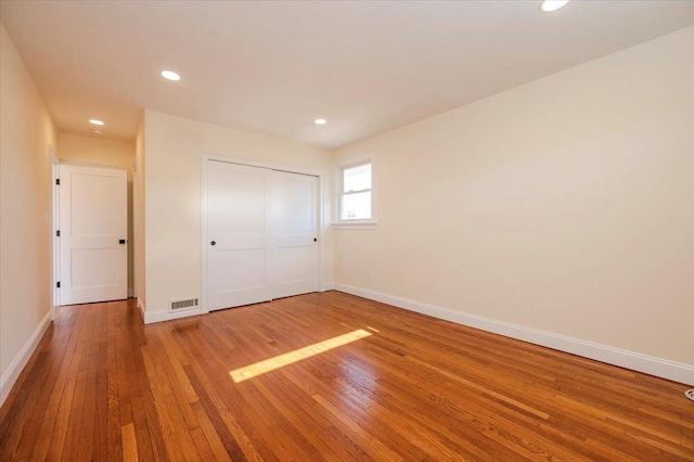 unfurnished bedroom with hardwood / wood-style floors and a closet