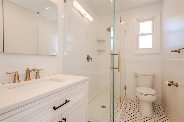 bathroom featuring toilet, a shower with shower door, tile walls, tile patterned floors, and vanity