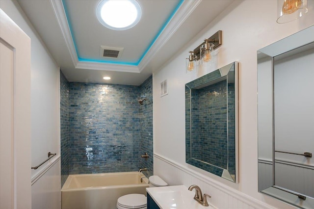 full bathroom with tiled shower / bath combo, toilet, a raised ceiling, ornamental molding, and vanity