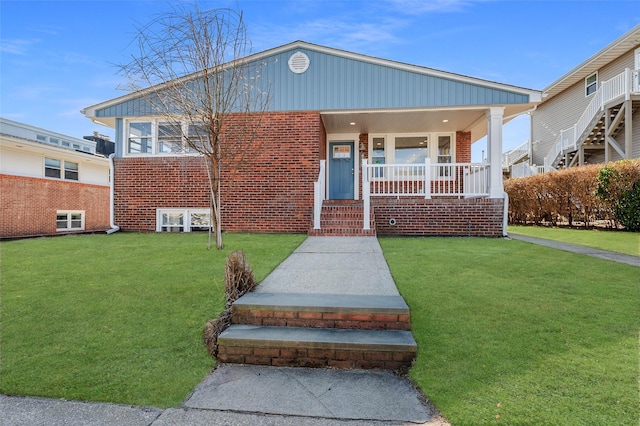 bungalow-style home with covered porch and a front lawn