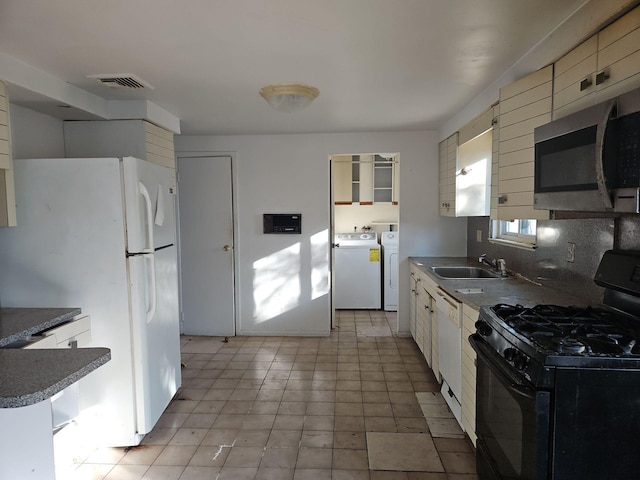 kitchen with white cabinetry, washer and clothes dryer, tasteful backsplash, white appliances, and sink