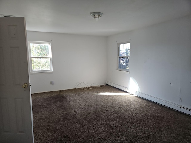 carpeted empty room featuring baseboard heating