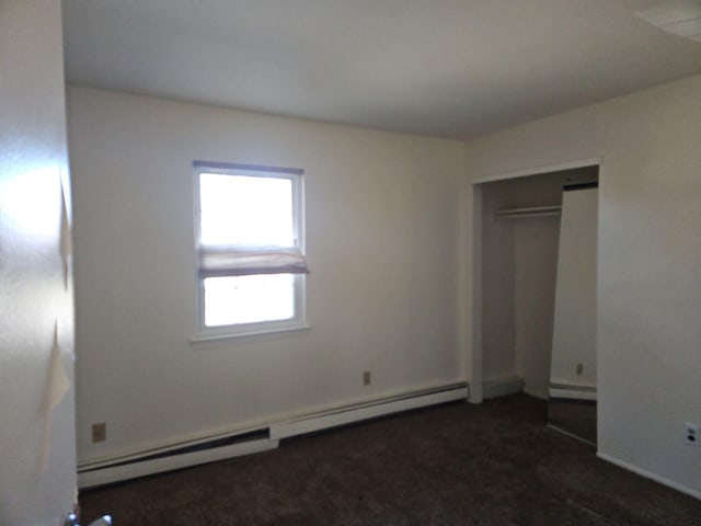 unfurnished bedroom with a baseboard radiator and a closet