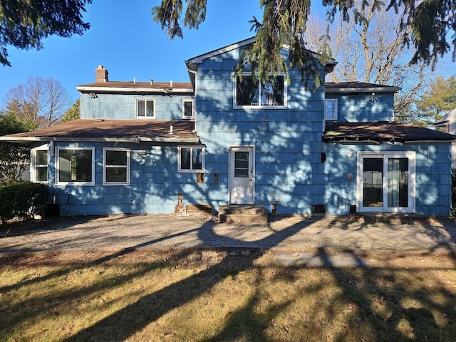 rear view of house featuring a yard