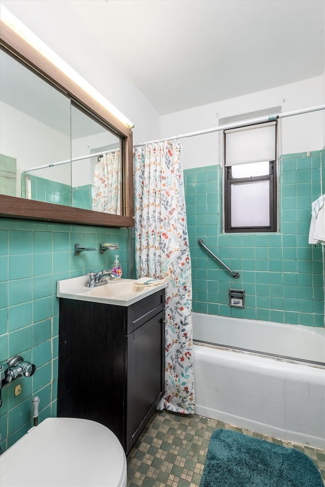 full bathroom with vanity, shower / tub combo, tile walls, and toilet