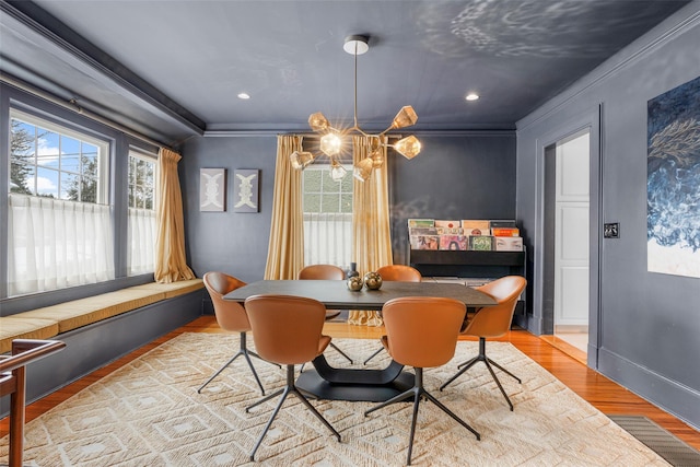 dining room featuring crown molding, light hardwood / wood-style flooring, and a chandelier