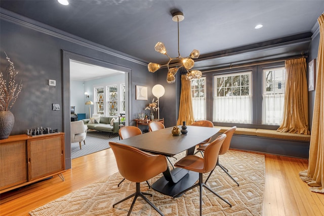 dining area with crown molding and light wood-type flooring