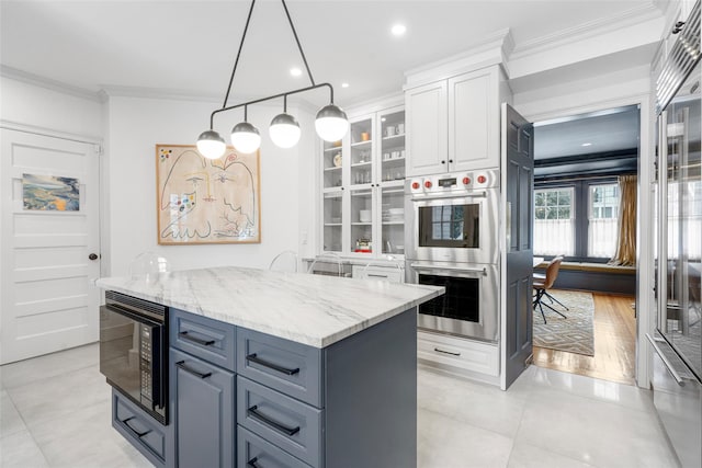 kitchen featuring light stone counters, hanging light fixtures, black microwave, double oven, and white cabinets