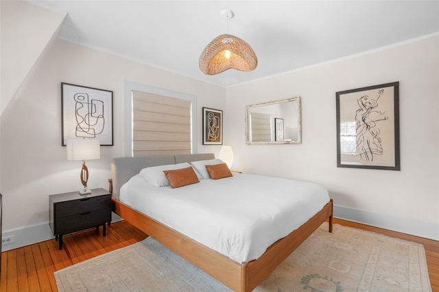 bedroom with hardwood / wood-style flooring and ornamental molding