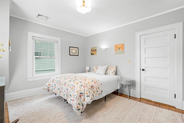 bedroom featuring wood-type flooring and ornamental molding