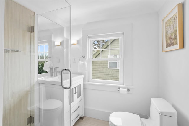 bathroom with plenty of natural light, toilet, a shower with door, and vanity