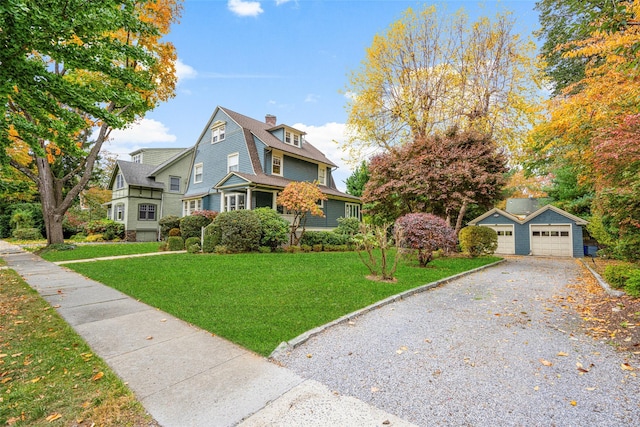 view of front property with a garage, an outdoor structure, and a front yard