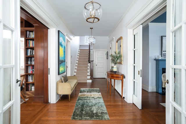 entryway with a chandelier, crown molding, dark hardwood / wood-style flooring, and french doors