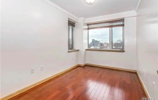 unfurnished room with wood-type flooring and crown molding