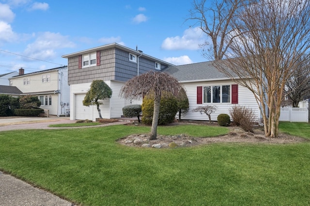 view of front of property with a front yard and a garage