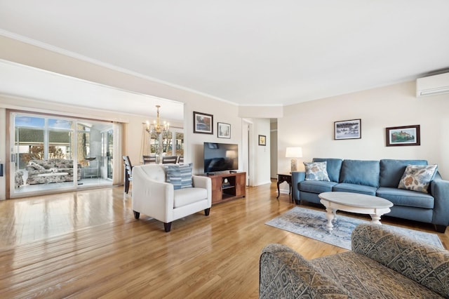 living room featuring a wall unit AC, a healthy amount of sunlight, light hardwood / wood-style flooring, and a notable chandelier