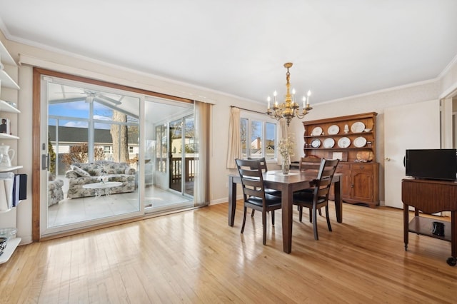 dining space with ceiling fan with notable chandelier, ornamental molding, and light hardwood / wood-style floors