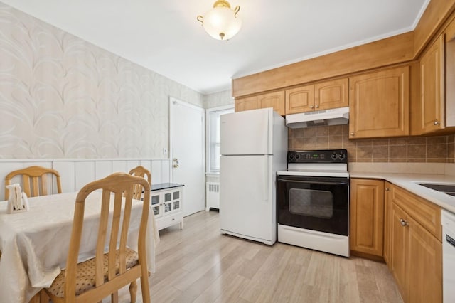 kitchen featuring light hardwood / wood-style flooring, radiator heating unit, tasteful backsplash, and white appliances