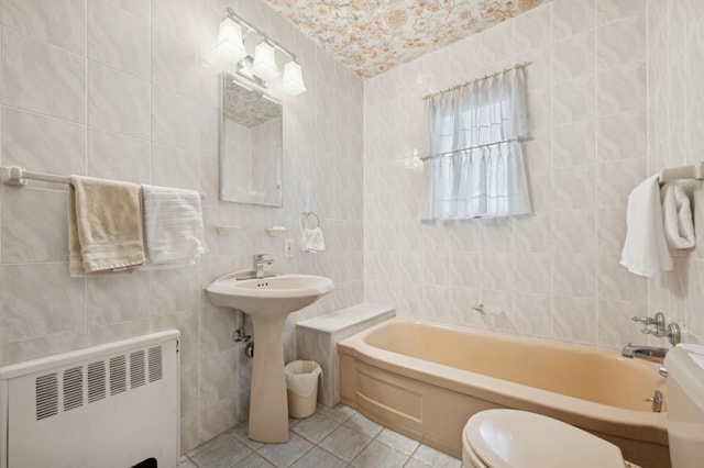 bathroom with toilet, tile walls, tile patterned floors, a tub, and radiator