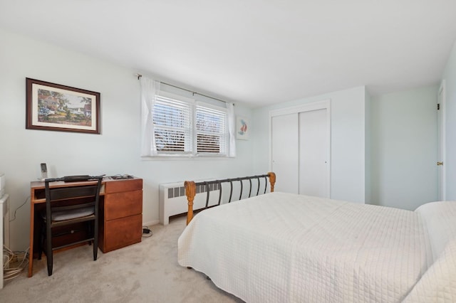 bedroom featuring light carpet, a closet, and radiator heating unit