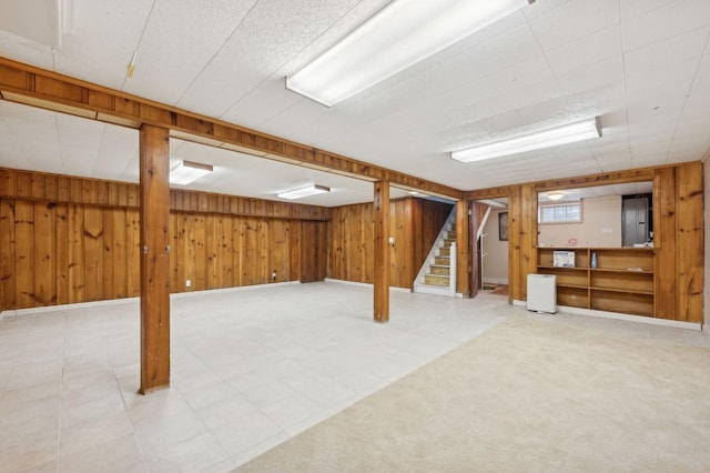 basement featuring carpet and wooden walls