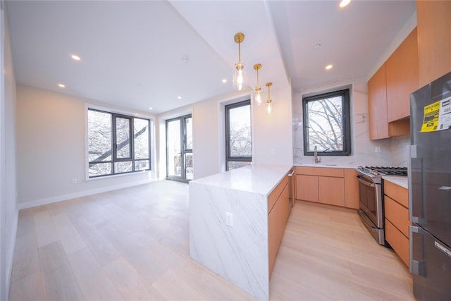 kitchen featuring light stone countertops, sink, tasteful backsplash, stainless steel range with gas cooktop, and kitchen peninsula