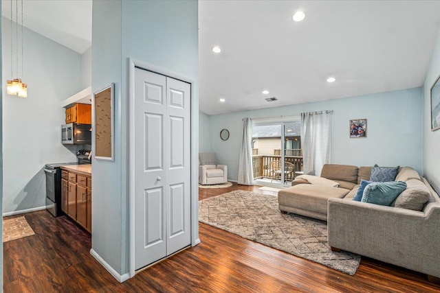 living room with dark hardwood / wood-style flooring and vaulted ceiling