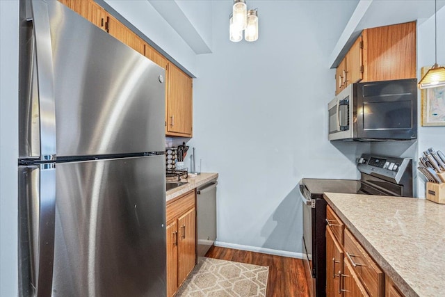 kitchen with dark hardwood / wood-style flooring, pendant lighting, and appliances with stainless steel finishes