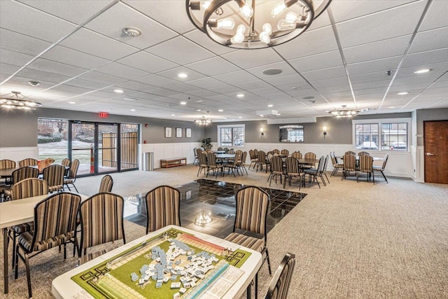 dining room with carpet flooring and a notable chandelier