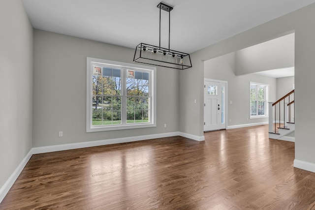 unfurnished dining area featuring a healthy amount of sunlight and dark wood-type flooring