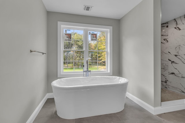 bathroom with separate shower and tub and tile patterned flooring