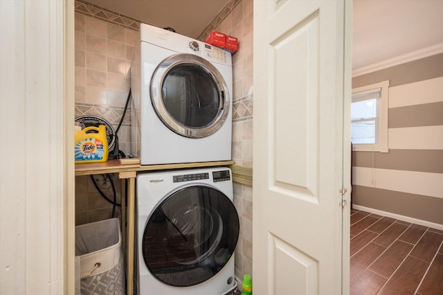 washroom with stacked washer / drying machine and ornamental molding