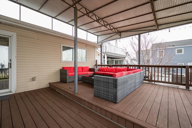 wooden terrace with an outdoor living space