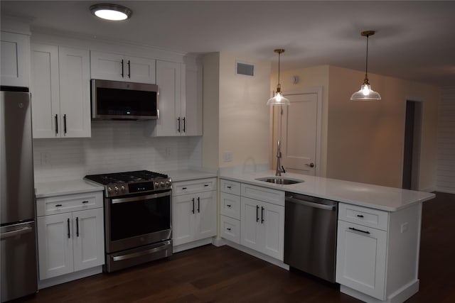 kitchen with light countertops, visible vents, appliances with stainless steel finishes, a sink, and a peninsula