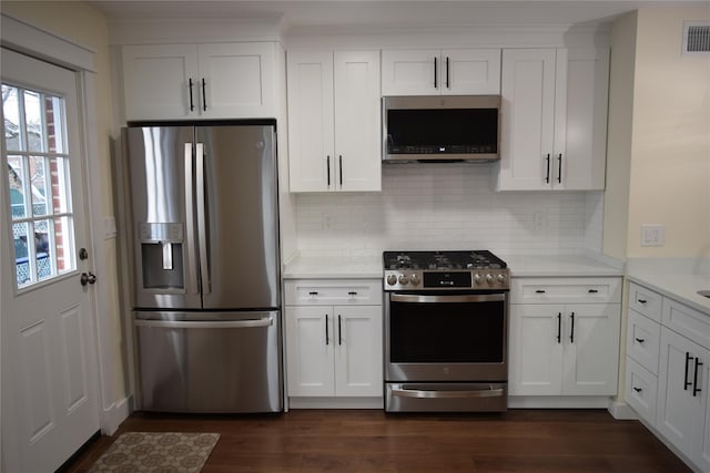 kitchen with stainless steel appliances, light countertops, dark wood-type flooring, and white cabinetry