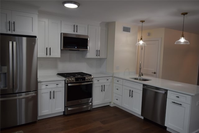 kitchen featuring light countertops, visible vents, appliances with stainless steel finishes, dark wood-type flooring, and a peninsula